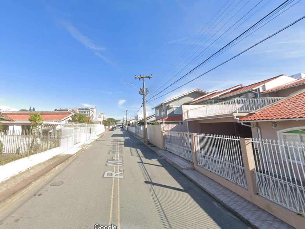 Rua residencial com casas e calçadas bem cuidadas representa a tranquilidade e organização do bairro Jardim Atlântico SC em Florianópolis.