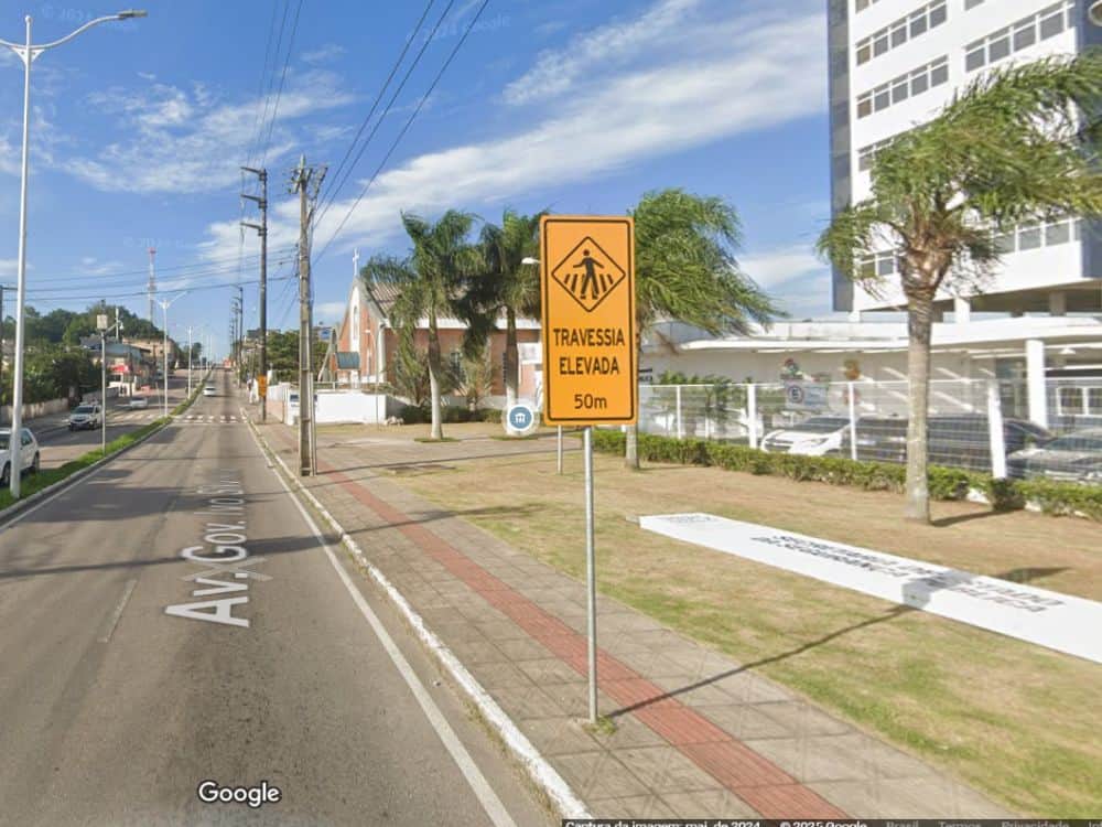 Sinalização de trânsito em via urbana do bairro Capoeiras em Florianópolis, destacando infraestrutura e segurança para pedestres.