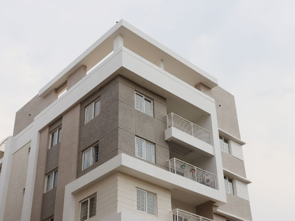 Fachada moderna de edifício residencial com unidades no estilo de apartamento padrão, comum em áreas urbanas bem localizadas.