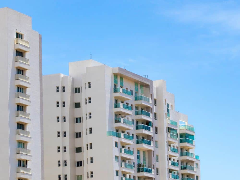 Edifício vertical com apartamentos padrão, estrutura típica de moradia urbana com varanda e cômodos bem distribuídos.