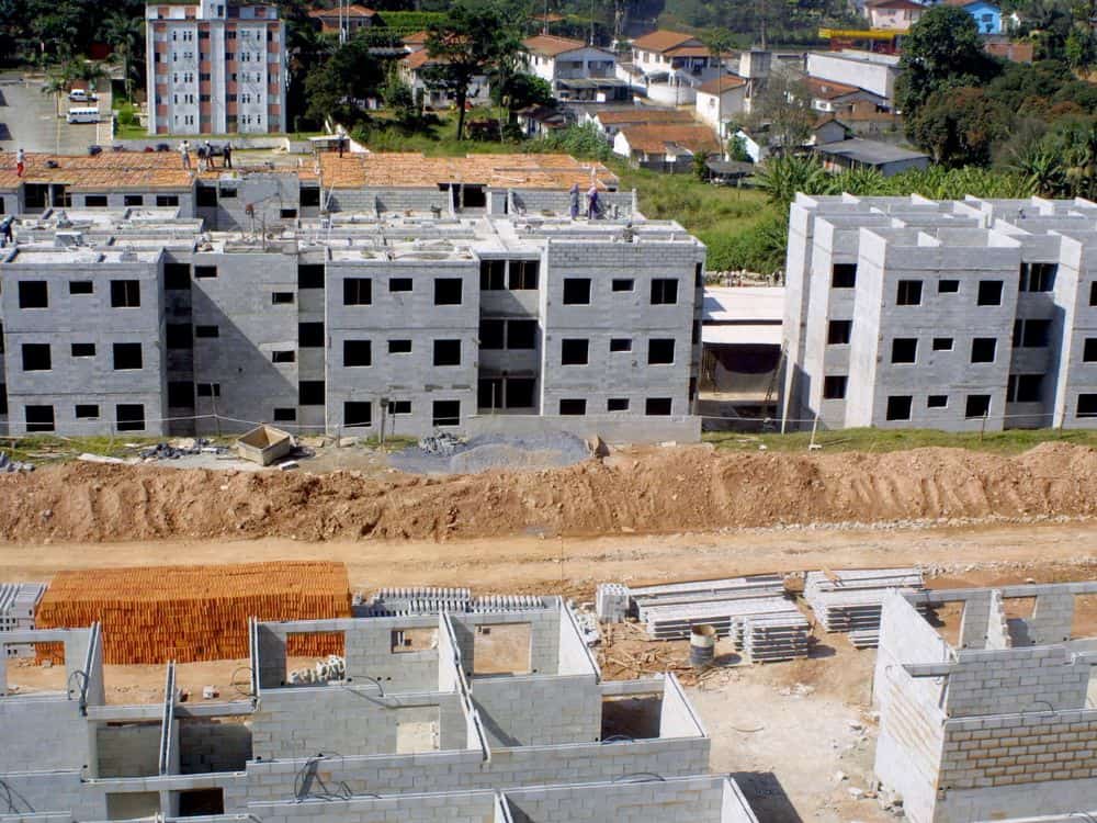 Conjunto habitacional em construção seguindo o modelo de apartamento padrão, com estrutura funcional e divisão tradicional de cômodos.