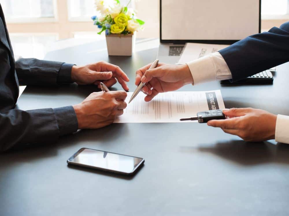 Assinatura de contrato ilustrando o direito de preferência do locatário na compra do imóvel alugado.